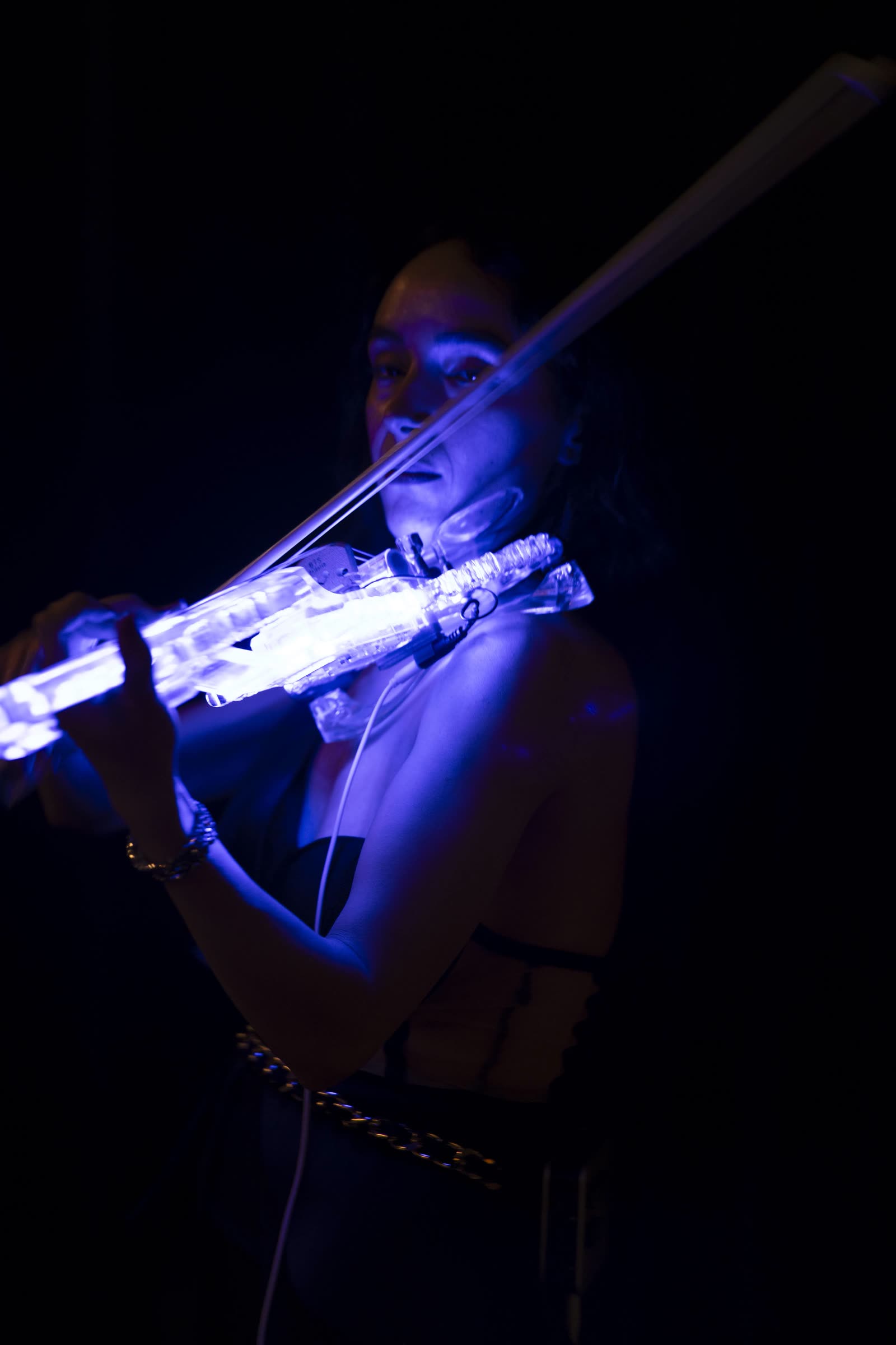 The violin glowing in near-darkness